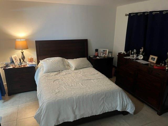 A bedroom features a dark wood bed frame, matching nightstands, and dark blue curtains — 7410 SW 82nd St # K206, Miami FL 33143, MIAMI, FL