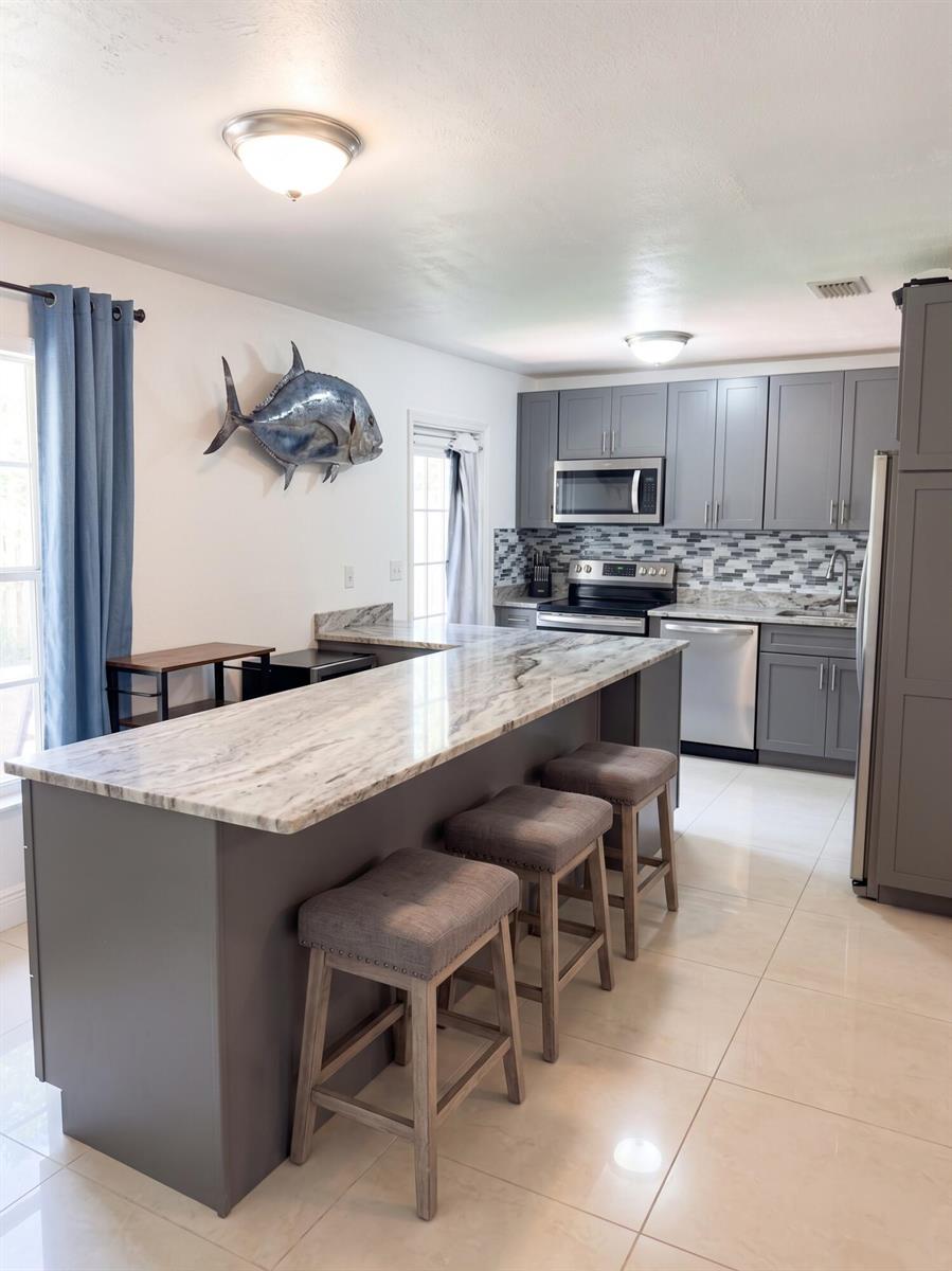 A single-story house with a pink paved driveway, a black car, and a boat parked outside — 1230 NE 26th Terrace, Pompano Beach FL 33062, POMPANO BEACH, FL