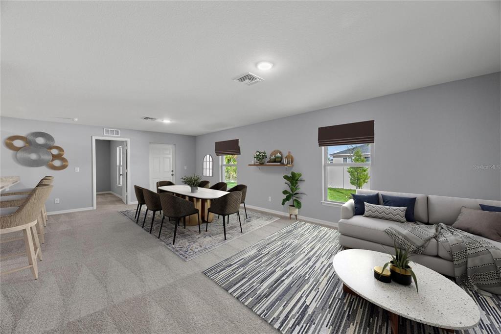 This open-concept living and dining area features neutral carpeting, gray walls, and modern furniture — 2295 W SWANSON DRIVE, CITRUS SPRINGS, FL