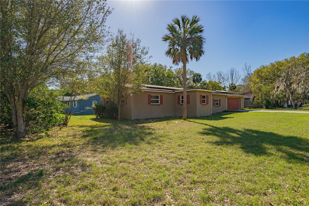 A tan, single-story house with a garage and a palm tree in the front yard — 805 S STONE STREET, DELAND, FL