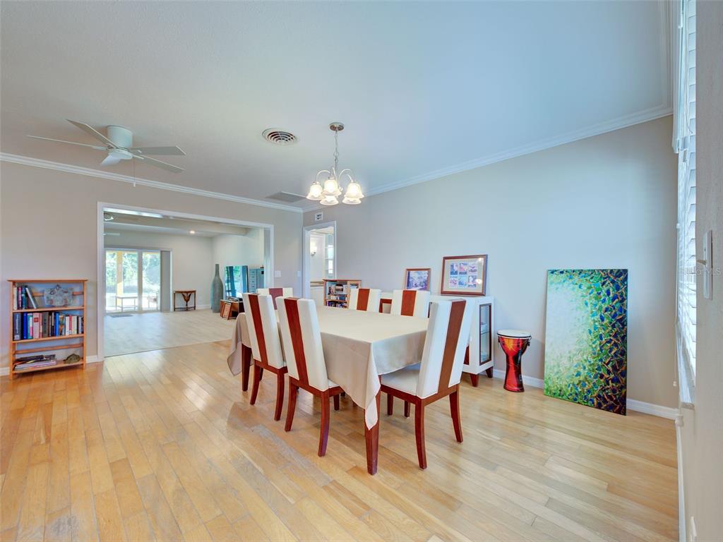 A dining room with a table, chairs, light-colored wood floors, and a ceiling fan — 836 STEWART STREET, ENGLEWOOD, FL
