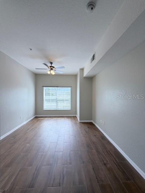 An empty room with wood-look tile flooring, a ceiling fan, and a window — 2201 SAN VITTORINO CIRCLE UNIT 106, KISSIMMEE, FL