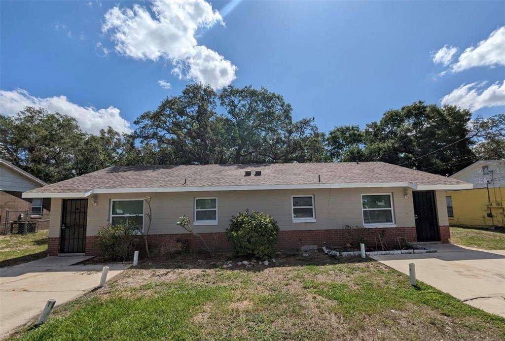 A single-story duplex with a tan exterior, brick base, and two separate front entrances — 511 N JOHN STREET, ORLANDO, FL