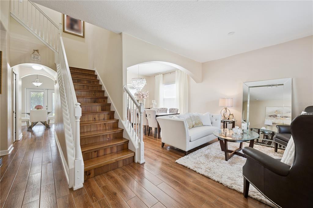 A staircase with wood treads leads to an upper level beside a living room — 1454 LAKE SIDE AVENUE, DAVENPORT, FL