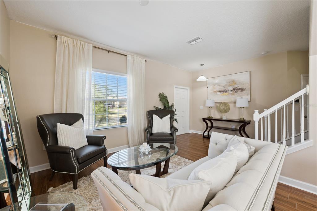 A living room features a white sofa, two dark leather armchairs, and a glass coffee table — 1454 LAKE SIDE AVENUE, DAVENPORT, FL
