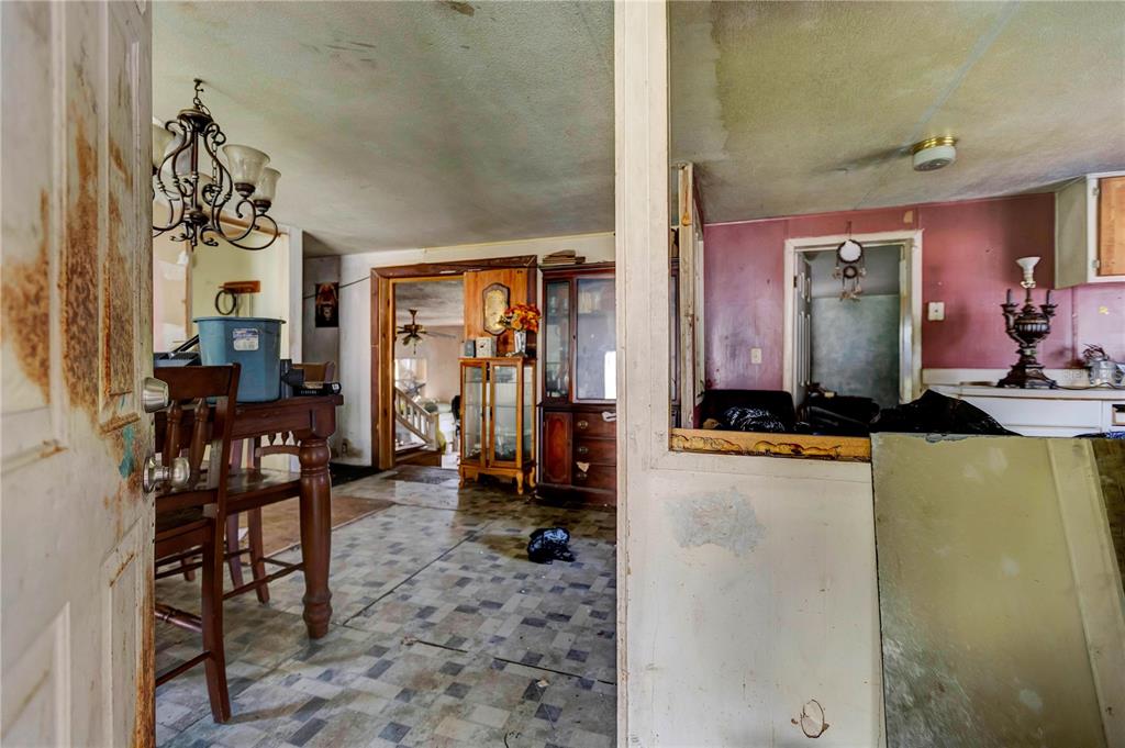 An interior view shows a dining area with a chandelier leading to a living space — 2614 KYLE STREET, LAKELAND, FL