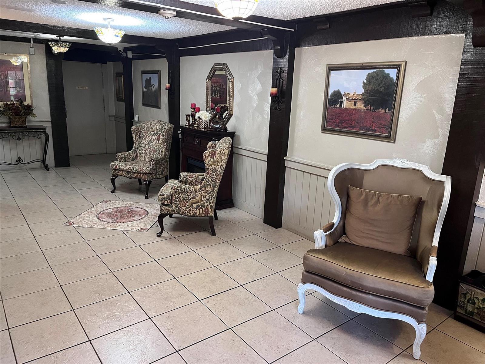 A waiting area features tiled floors, dark wood beams, and three upholstered armchairs — 3670 N Inverrary Drive # 1F, Lauderhill FL 33319, LAUDERHILL, FL