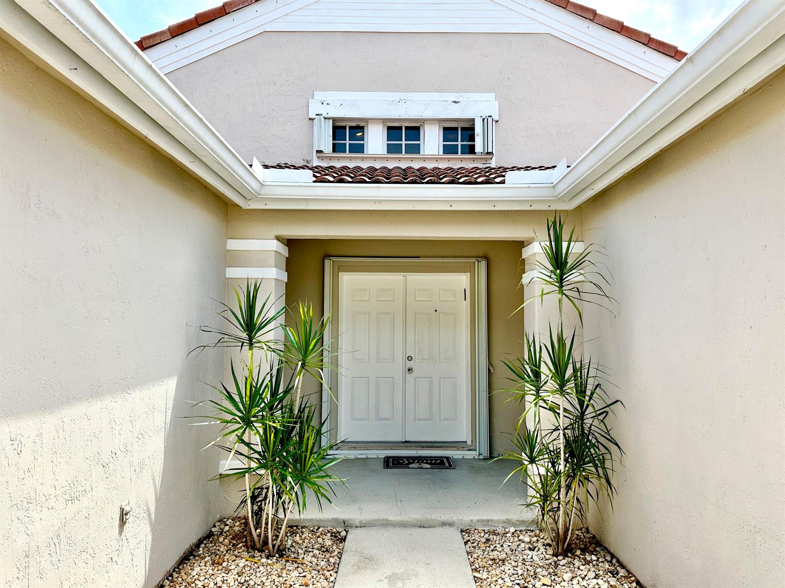The exterior entryway features double white doors, two potted plants, and a small transom window — 386 Carrington Drive, Weston FL 33326, WESTON, FL