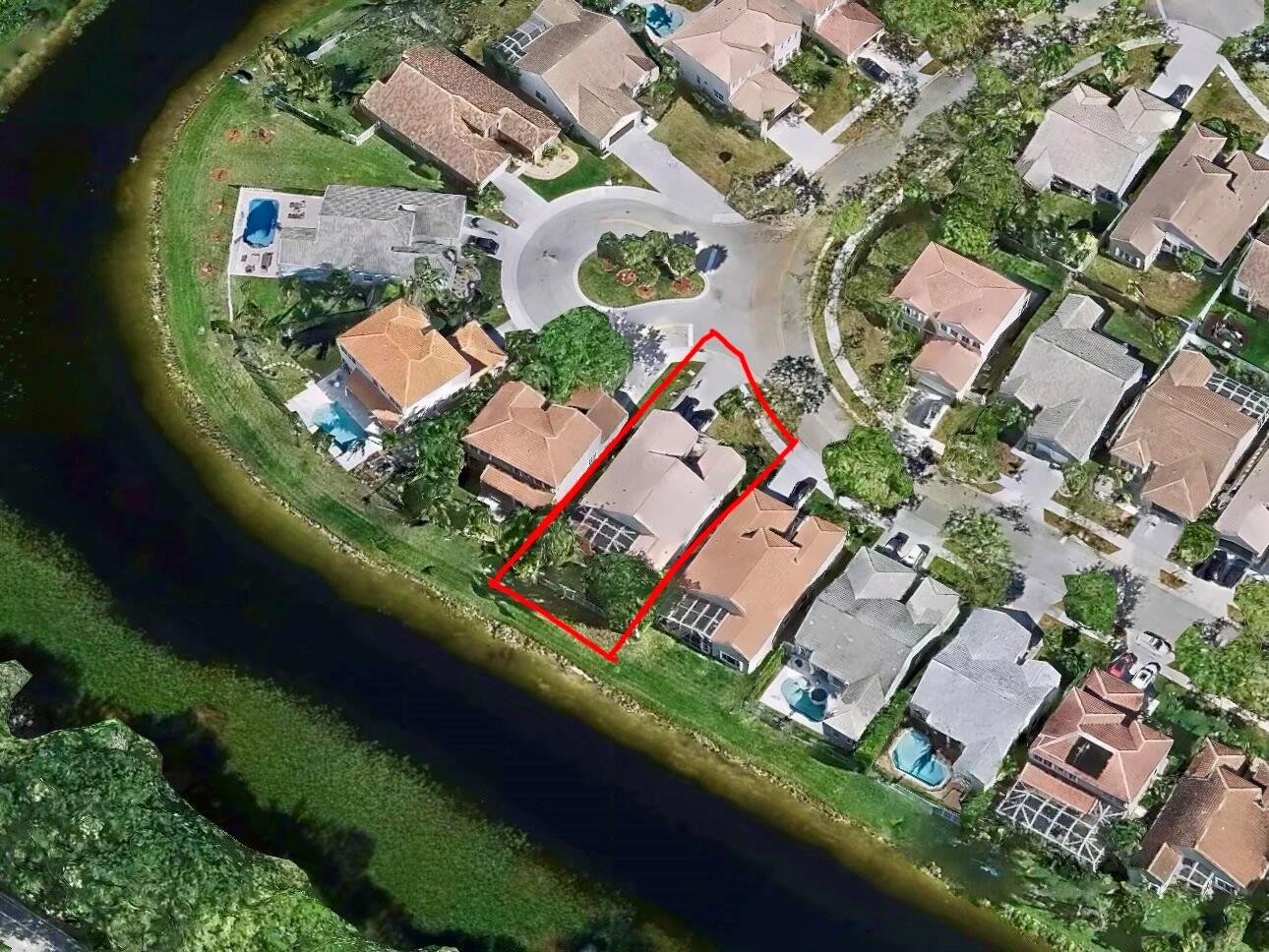 Aerial view of a residential property highlighted in red, situated along a canal — 386 Carrington Drive, Weston FL 33326, WESTON, FL