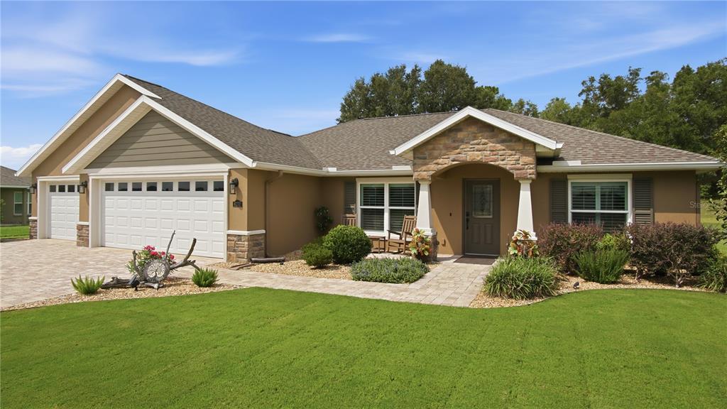 A single-story house with a stone-accented entryway, a paved driveway, and a manicured front lawn — 6752 SW 179TH COURT ROAD, DUNNELLON, FL