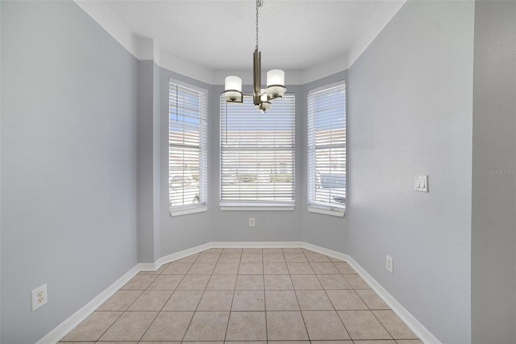 A dining nook with light gray walls, tile flooring, a bay window, and a chandelier — 1236 SOUTH BEACH CIRCLE, KISSIMMEE, FL