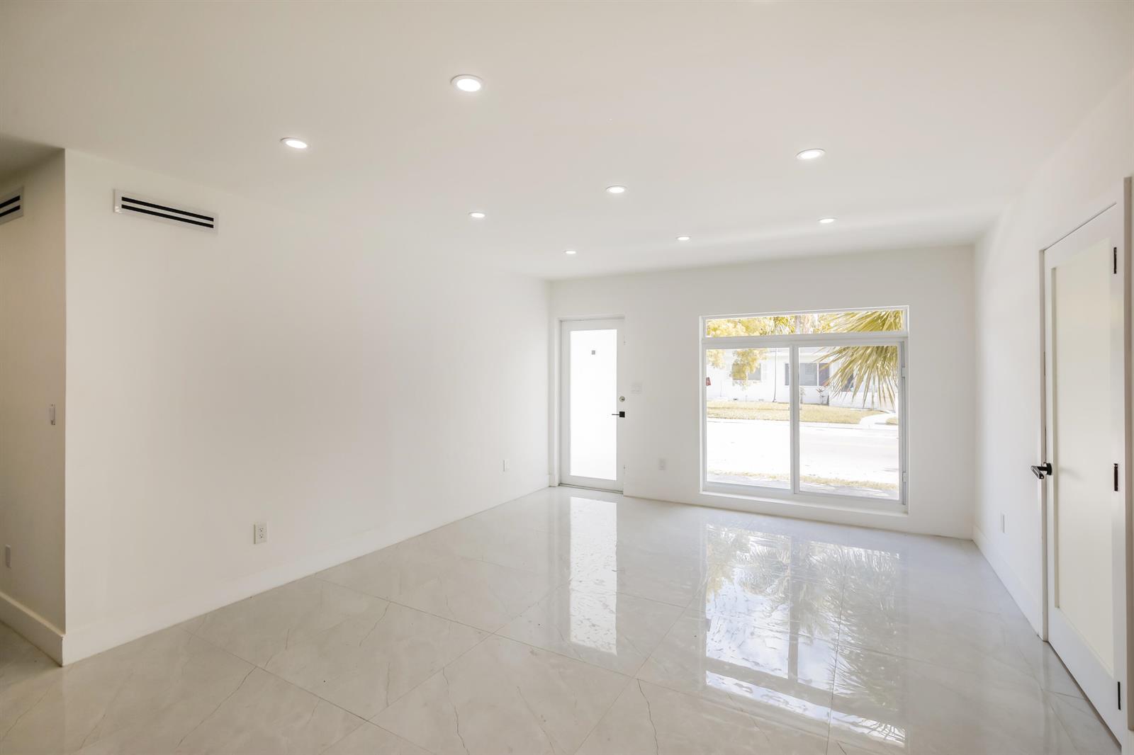 A bright, empty room features white walls, recessed ceiling lights, and polished light-colored tile flooring — 4701 SW 7th Street, Miami FL 33134, MIAMI, FL