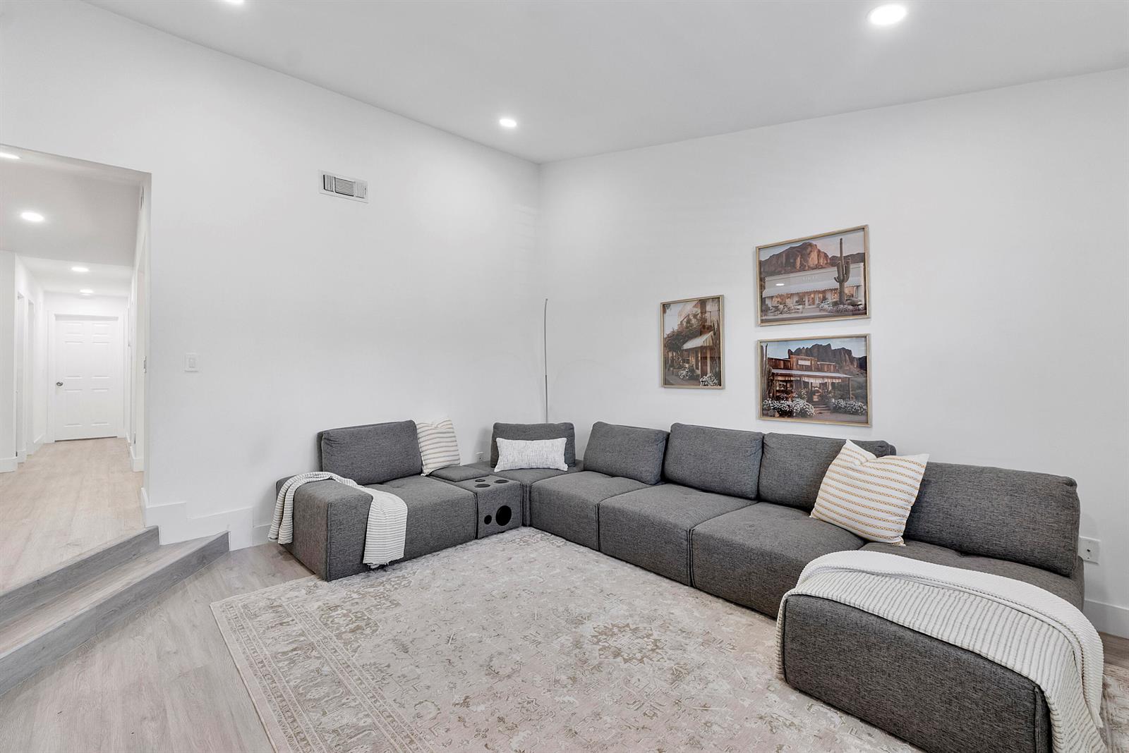 A living room features a large gray sectional sofa, a patterned rug, and wall art — 23284 SW 53rd Avenue # D, Boca Raton FL 33433, BOCA RATON, FL