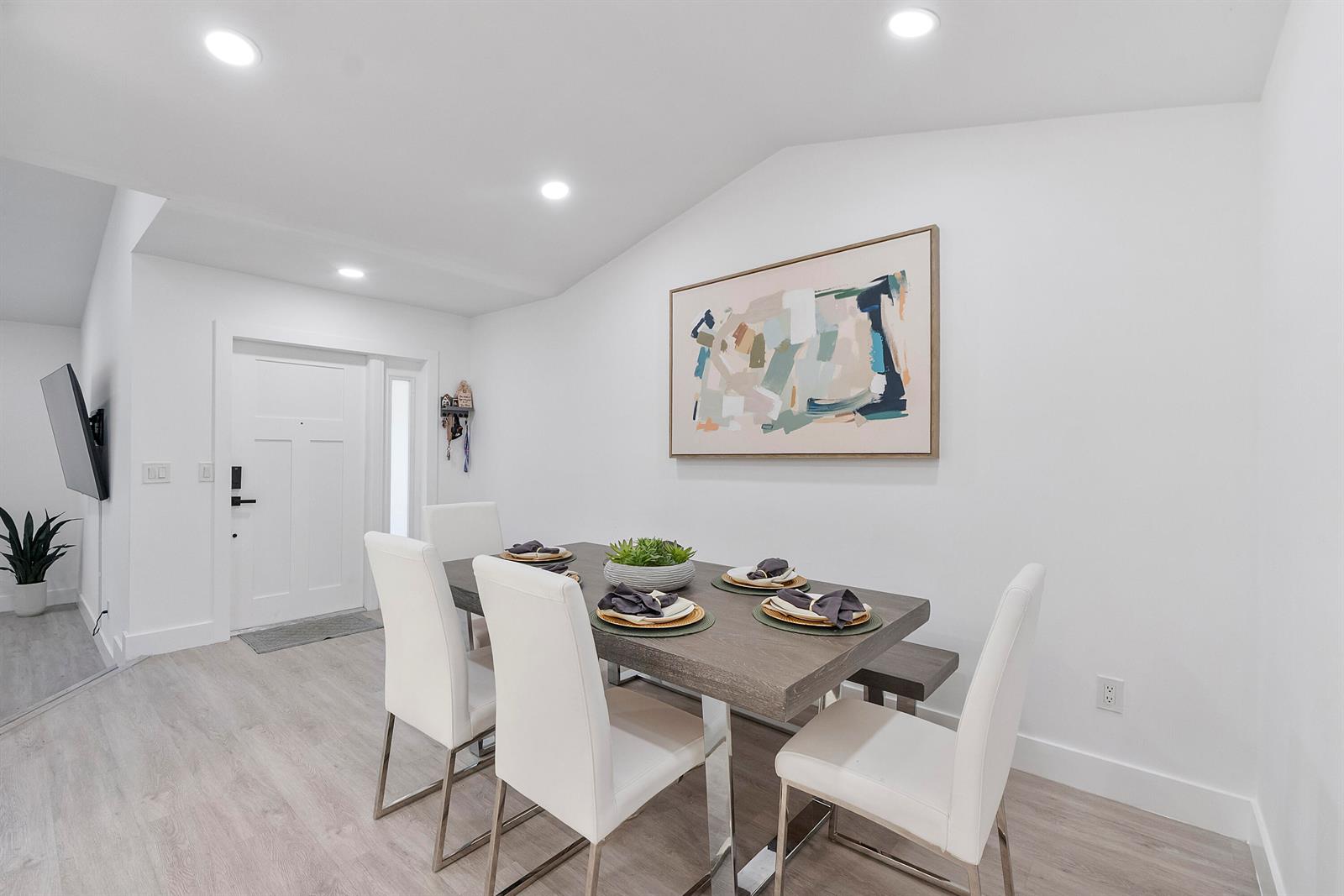 A dining room features a wooden table, white chairs, and abstract wall art — 23284 SW 53rd Avenue # D, Boca Raton FL 33433, BOCA RATON, FL