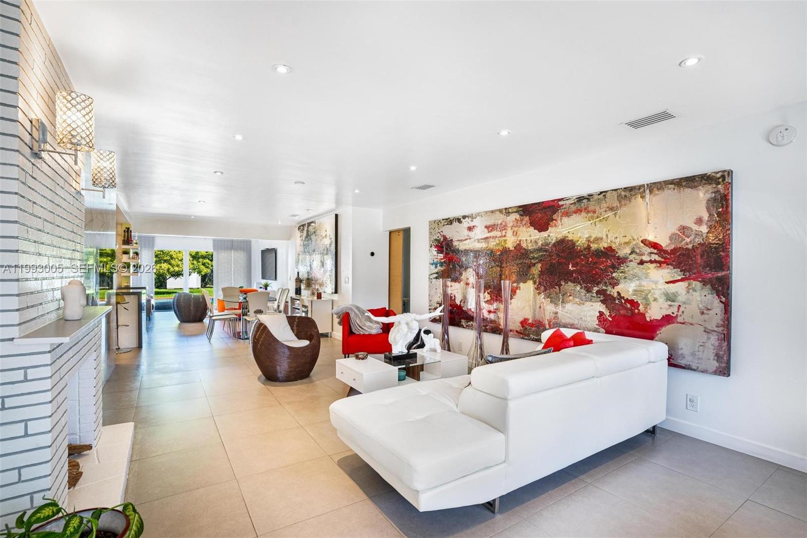 A modern living room features a white sectional sofa, large abstract art, and tile flooring — 2923 Madison St, Hollywood FL 33020, HOLLYWOOD, FL