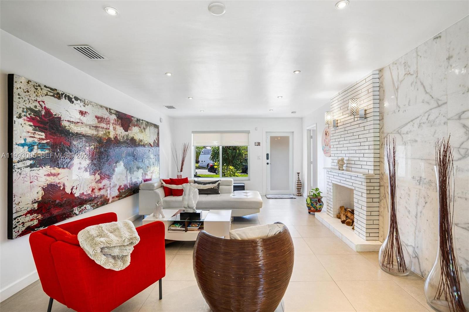A living room features a large abstract painting, a white brick fireplace, and tile flooring — 2923 Madison St, Hollywood FL 33020, HOLLYWOOD, FL