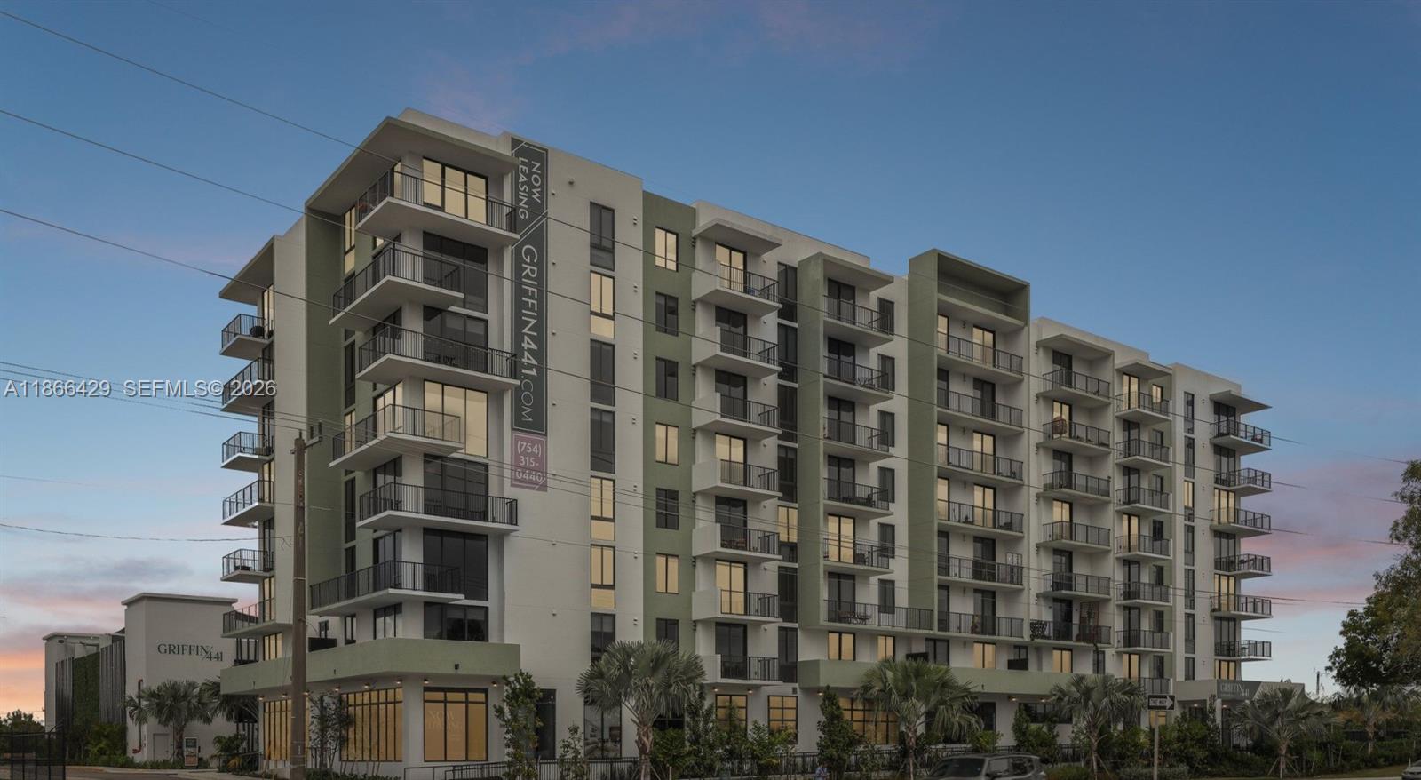 A modern multi-story apartment building features balconies and a prominent vertical sign on its facade — 4465 Griffin Road, Davie FL 33314, DAVIE, FL