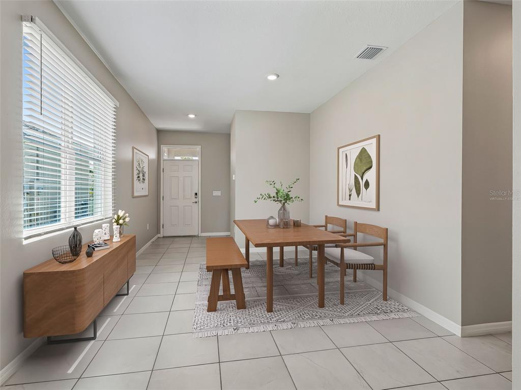 A dining area features a wooden table with a bench and chairs on tile flooring — 5072 STOKES WAY, WILDWOOD, FL