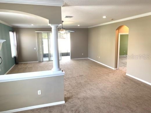 An open-concept living area features beige carpeting, neutral walls, and a white architectural column — 2520 PEEKSKILL ROAD, VALRICO, FL