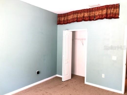A bedroom with light blue walls, brown carpet, and a closet with a white door — 2520 PEEKSKILL ROAD, VALRICO, FL