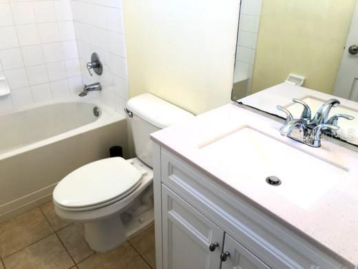 A bathroom features a white vanity with a sink, a toilet, and a bathtub — 2520 PEEKSKILL ROAD, VALRICO, FL