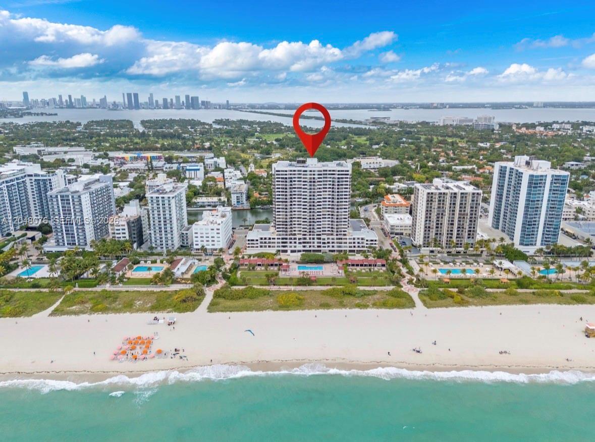 An aerial view of a beachfront high-rise condominium building with a red location marker — 2555 Collins Ave # 1101, Miami Beach FL 33140, MIAMI BEACH, FL