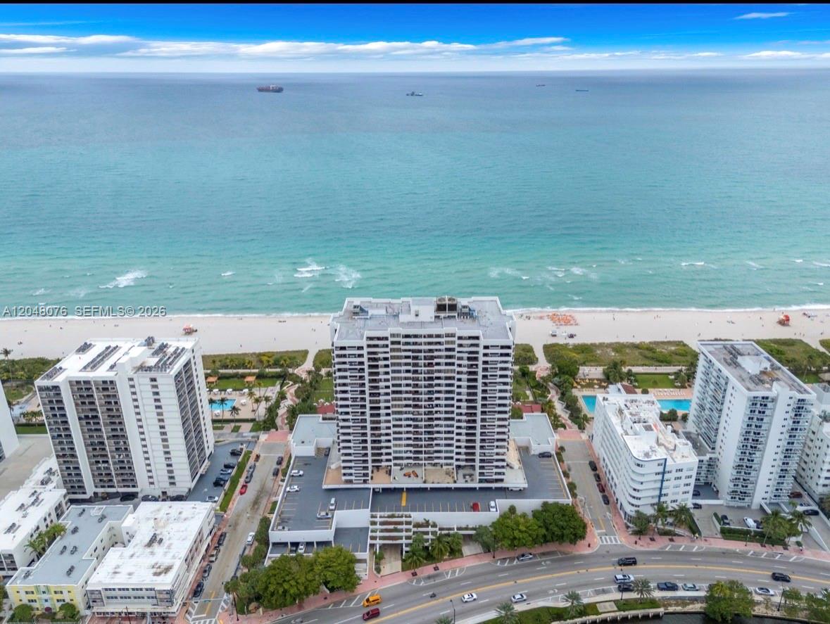An aerial view shows a high-rise condominium building situated directly on a sandy beach — 2555 Collins Ave # 1101, Miami Beach FL 33140, MIAMI BEACH, FL