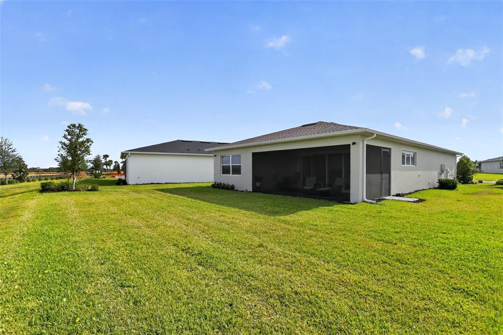 A modern single-story house with a gray garage, paved driveway, and landscaped front yard — 1599 BELLAGIO LOOP, TAVARES, FL