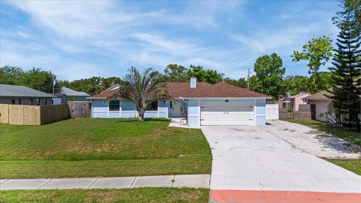 A light blue single-story house with a two-car garage and a front lawn — 2350 Fallon Boulevard NE, Palm Bay FL 32907, PALM BAY, FL