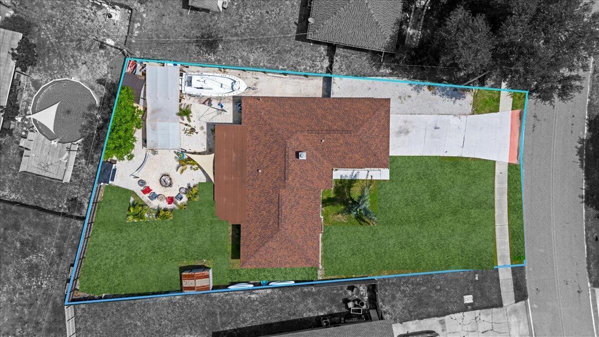 An aerial view shows a residential property with a house, driveway, and backyard landscaping — 2350 Fallon Boulevard NE, Palm Bay FL 32907, PALM BAY, FL