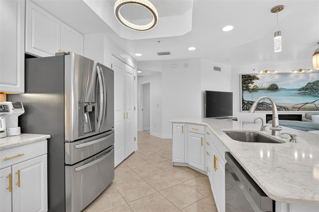 A modern kitchen features white cabinets, stainless steel appliances, and a marble-topped island — 3426 HANCOCK BRIDGE PARKWAY UNIT 1008, NORTH FORT MYERS, FL