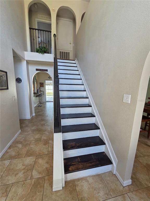 A staircase with dark treads and white risers leads to an upper landing — 1389 TIMBERHILL STREET, NORTH PORT, FL