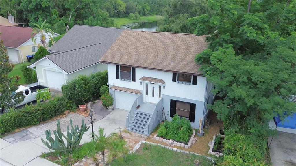 An elevated two-story house with a white exterior, gray lower level, and a shingled roof — 238 LAKE DRIVE, ORLANDO, FL