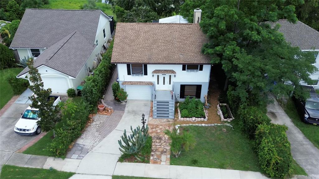 An aerial view shows a two-story house with a brown roof, white siding, and driveway — 238 LAKE DRIVE, ORLANDO, FL
