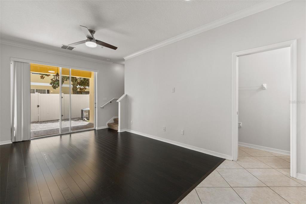A living room features dark hardwood floors, a ceiling fan, and sliding glass doors to a patio — 14030 SPARKLING COVE LANE UNIT 603, WINDERMERE, FL