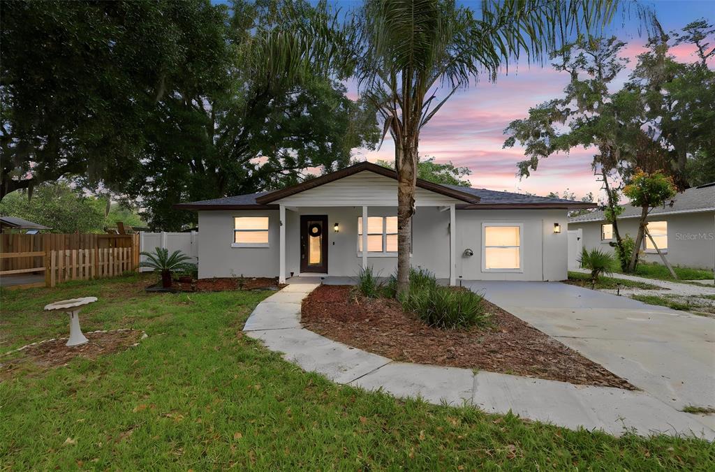 A single-story house with a white exterior, a front porch, and a concrete walkway — 2602 WESTSIDE DRIVE, LEESBURG, FL