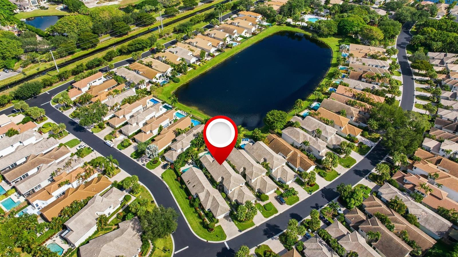 An aerial view of a residential neighborhood featuring a large pond and a marked townhouse — 2495 NW 66th Drive, Boca Raton FL 33496, BOCA RATON, FL