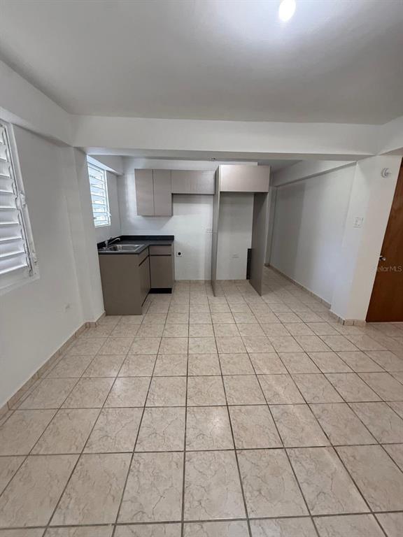 A kitchen features light-colored tile flooring, neutral cabinets, and a stainless steel sink — Aibonito LA PLATA, AIBONITO, PR