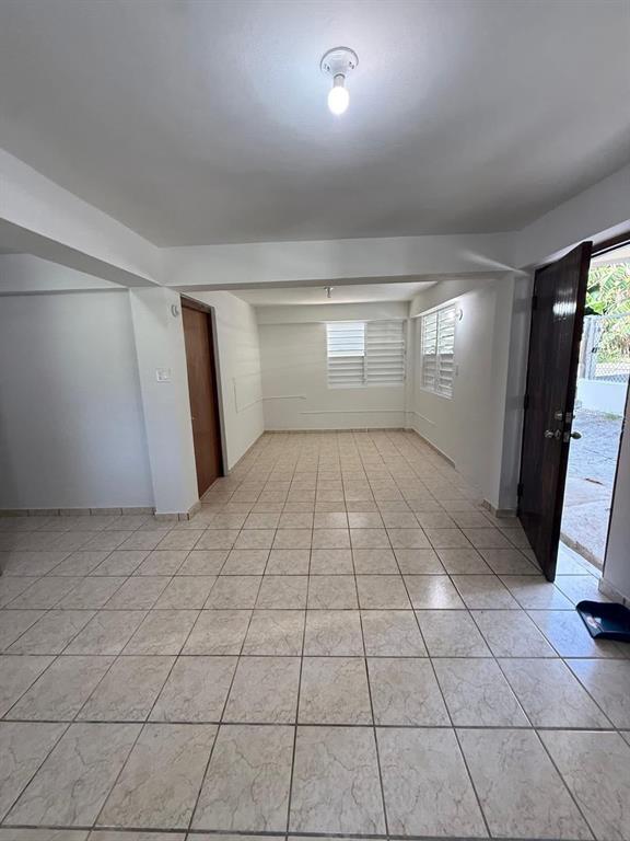 An interior view of a room with light-colored tile flooring, white walls, and an open door — Aibonito LA PLATA, AIBONITO, PR