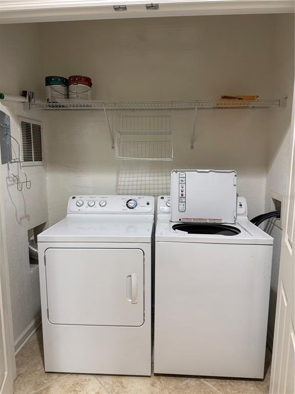 A laundry closet contains a white dryer and a top-loading washing machine under wire shelving — 6335 CONTESSA DRIVE UNIT 107, ORLANDO, FL