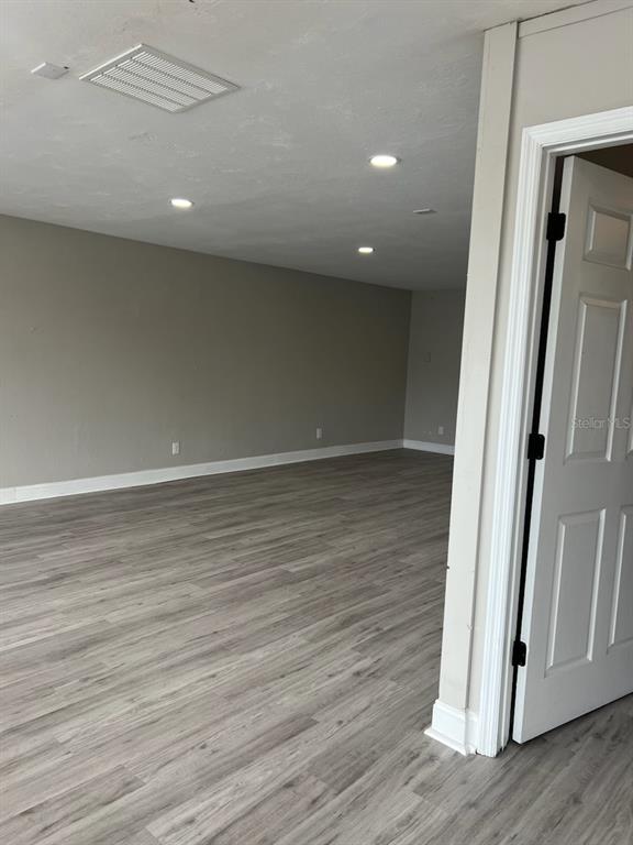An interior view shows a room with light gray wood-look flooring and recessed ceiling lighting — 1780 E DUVAL STREET Unit 120, LAKE CITY, FL