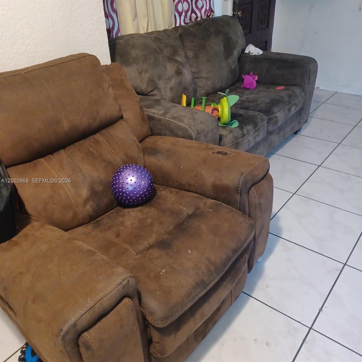 A brown recliner and matching sofa sit on a white tiled floor in a room — 5250 NW 24th Ave, Miami FL 33142, MIAMI, FL