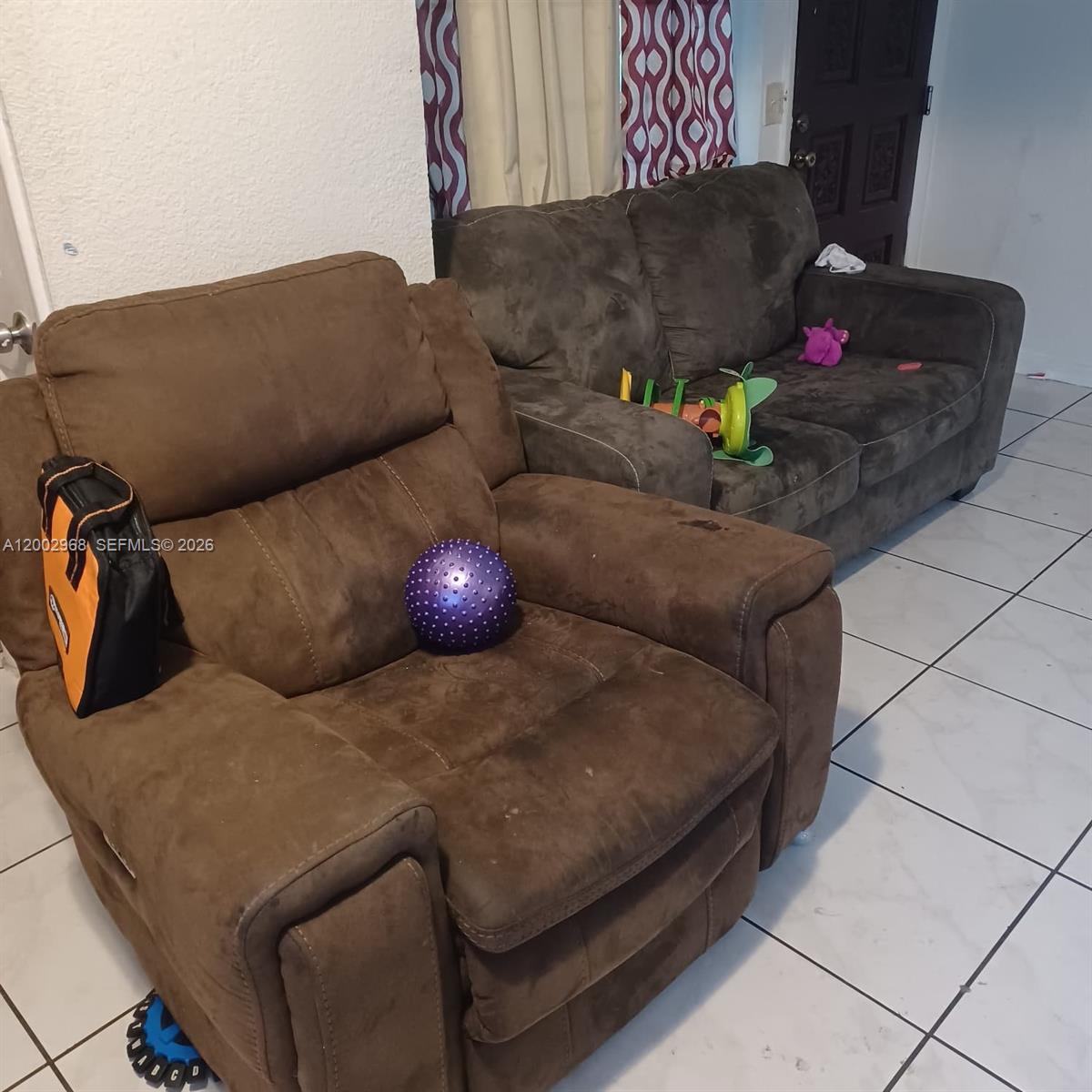 A brown recliner and a matching sofa sit on a white tiled floor — 5250 NW 24th Ave, Miami FL 33142, MIAMI, FL