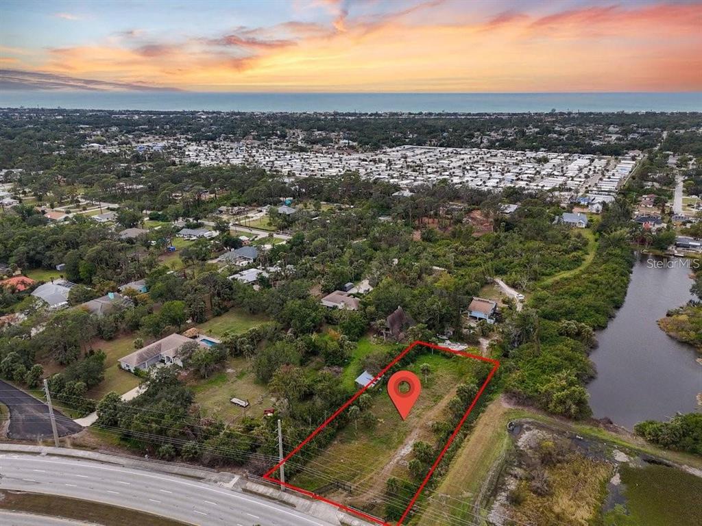 An aerial view shows a vacant rectangular lot outlined in red next to a road — ENGLEWOOD ROAD, VENICE, FL