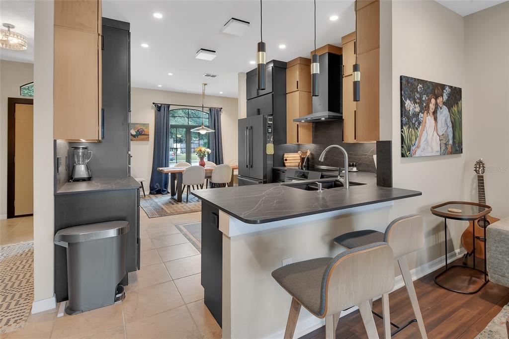 A kitchen features dark countertops, two-tone cabinetry, a breakfast bar, and an adjacent dining area — 404 COUNTRY VIEW CIRCLE, DELAND, FL