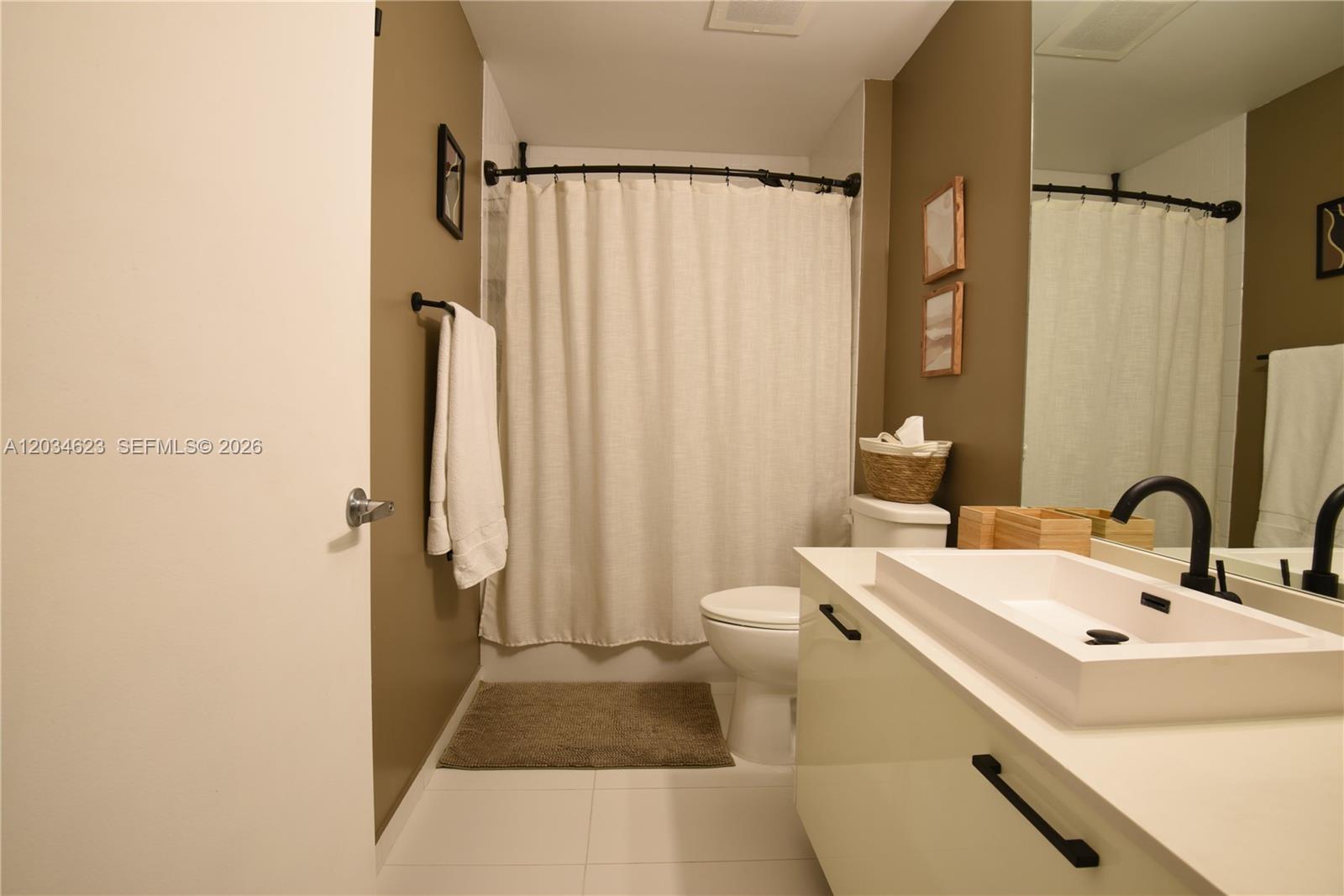 A bathroom features a white vanity with a vessel sink, a toilet, and a shower curtain — 151 SE 1st St # 1907, Miami FL 33131, MIAMI, FL