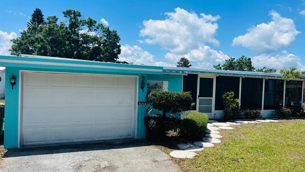 A turquoise house with a white garage door and a screened-in front porch — 14750 OLD US HIGHWAY 441, TAVARES, FL