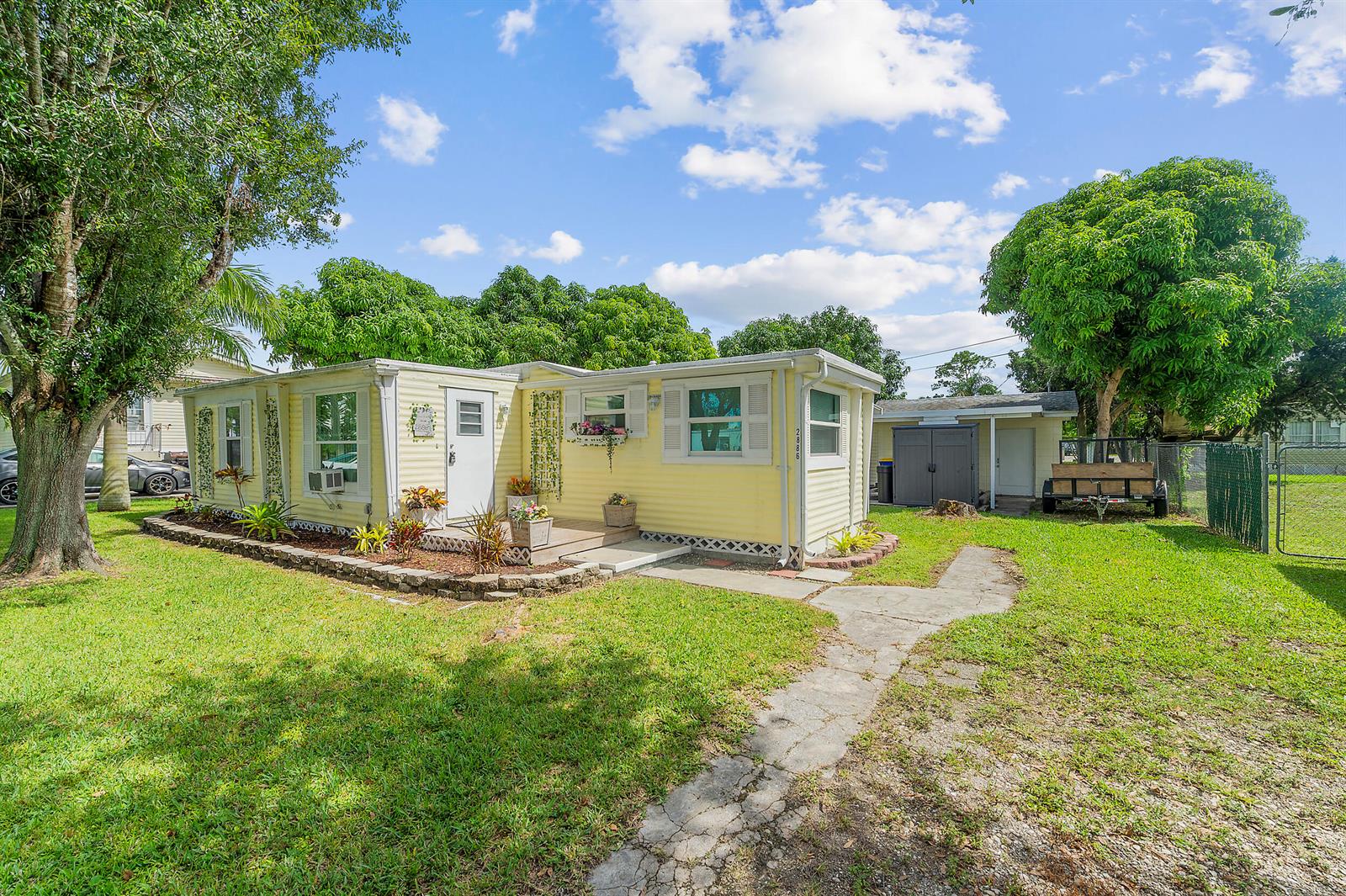 A yellow single-story house with a white door and a small front porch — 2886 SE La Palma Terrace, Stuart FL 34997, STUART, FL
