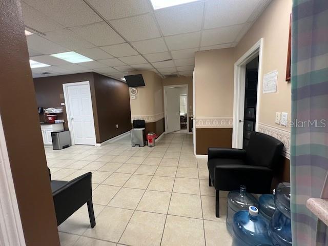 A waiting area with tiled floors, black chairs, and multiple doorways in a medical office — 101 CLEARWATER LARGO ROAD N, LARGO, FL