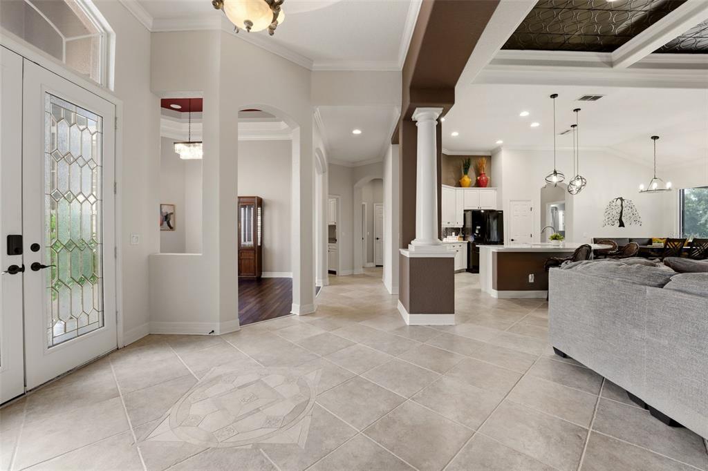 An entryway with tile flooring leads into an open-concept kitchen and living area — 515 SAND CRANE COURT, BRADENTON, FL